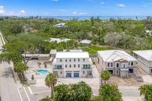 A residential property with a swimming pool, multiple buildings, and a view of the ocean.