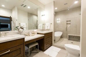 Een moderne badkamer met twee wastafels, een grote spiegel en een ruime douche.