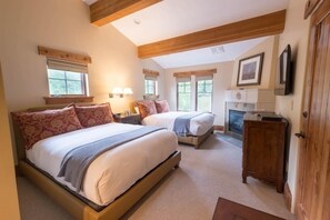 A bedroom with two beds, a fireplace, and wooden beams on the ceiling. - NEW! One Bedroom Two Queen Suite (Park City)