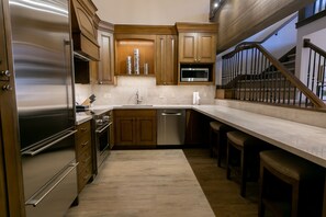 Una cocina moderna con armarios de madera, electrodomésticos de acero inoxidable y encimera de mármol.