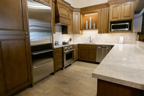 Una cocina moderna con armarios de madera, electrodomésticos de acero inoxidable y encimera de mármol.