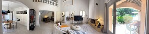 A spacious living area with a TV, seating, and a view of the outdoors.