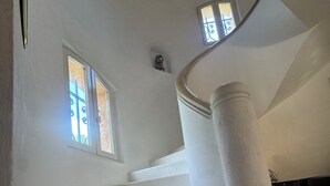 A staircase with white steps and columns, leading to a landing with a view of the outside. - Welcome to Villa Sulvia, located between the sea and the hinterland of Provence. (Roquefort-les-Pins)
