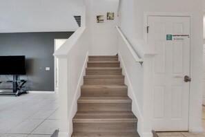 Eine Treppe mit einer weißen Tür, auf der 'Crofton Paradise' steht, und einem Schild, das kostenloses WLAN anzeigt.