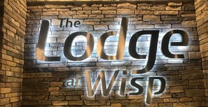 A wall with the text "The Lodge a Wisp" in large, metallic letters. - NEW! The Lodge at Wisp-1 BDRM King Sleeps 4 (McHenry)