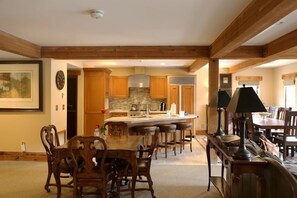 A spacious kitchen with wooden beams, a central island, and bar stools. - Upgraded Deluxe Mountain Studio (Park City)