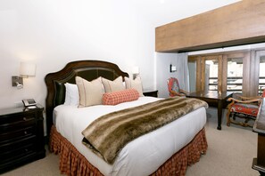 A hotel room with a large bed, a wooden headboard, a desk with a chair, and a large mirror. - NEW! Bald Eagle Two Bedroom (Park City)
