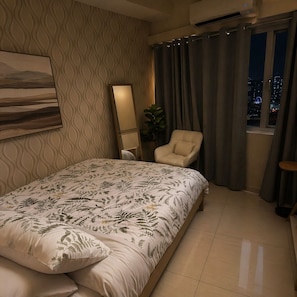 Ein Schlafzimmer mit Bett, Stuhl, Spiegel und einem Fenster mit Vorhängen.