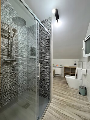 Une salle de bain moderne avec une douche Ă parois de verre, des toilettes et un lavabo.