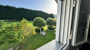 A view from a window overlooking a well-maintained garden with neatly trimmed hedges and a lawn. - Apartment at Casa Rural La Pradera with Mountain Views, Garden, and Wi-Fi (A Espiñeira)