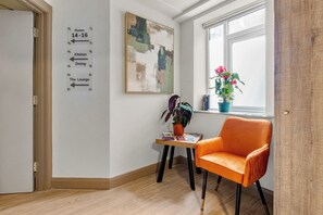 Un pasillo con indicaciones hacia las habitaciones 14 a 16, la cocina, el comedor y el salón.