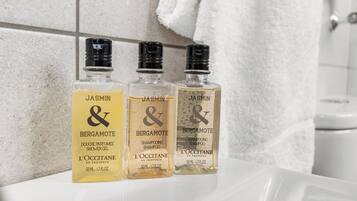 Three bottles of JASMIN & BERGAMOTE shampoo on a bathroom counter.