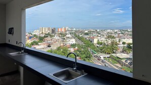 A kitchen with a large window overlooking a cityscape. - Condo with excellent views 10 minutes from the boardwalk Super equipped (Puerto Vallarta)