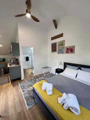 Ein modernes Hotelzimmer mit Bett, Schreibtisch und Deckenventilator.