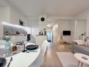 A modern living space with a dining area, kitchen, and a cozy seating area.