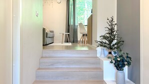 Eine Treppe führt zu einem Wohnbereich mit Blick auf Grün.