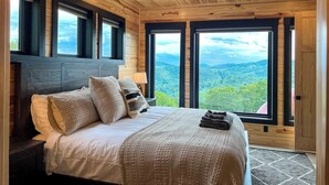 A bedroom with a large bed, multiple windows, and a ceiling fan. - Incredible Views *Arcade*Cinema*Sauna*Steamroom @ Peachtree Ridge (Boone)