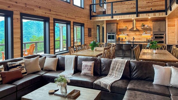 A spacious cabin interior with a large dining area, a cozy seating area, and a kitchen. - Incredible Views *Arcade*Cinema*Sauna*Steamroom @ Peachtree Ridge (Boone)