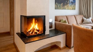 A modern living room with a fireplace, a sofa, and a coffee table. - Rauris Penthouse With Sauna (Rauris)