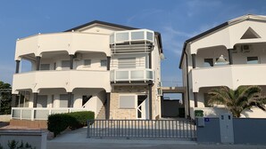 A multi-story residential building with balconies, a gated entrance, and a clear sky. - Apartment Lavaran 6 (Vir)