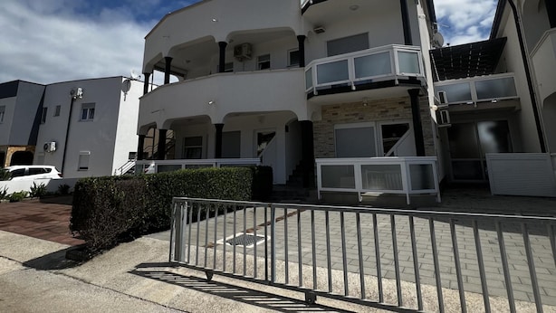 A multi-story residential building with balconies, satellite dishes, and a gated entrance. - Apartment Lavaran 6 (Vir)