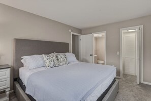 A bedroom with a bed, a nightstand, a door leading to a bathroom, and a closet. - Modern Corning Unit | Pet OK, Walk to CMOG/Gaffer (Corning)