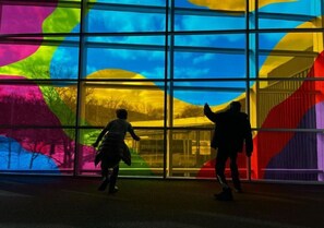 Ein Gebäude mit großen Fenstern und einer farbenfrohen Lichtinstallation.