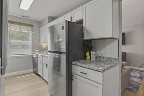 A modern kitchen with white cabinetry, a stainless steel refrigerator, and a granite countertop. - Modern Corning Unit | Pet OK, Walk to CMOG/Gaffer (Corning)