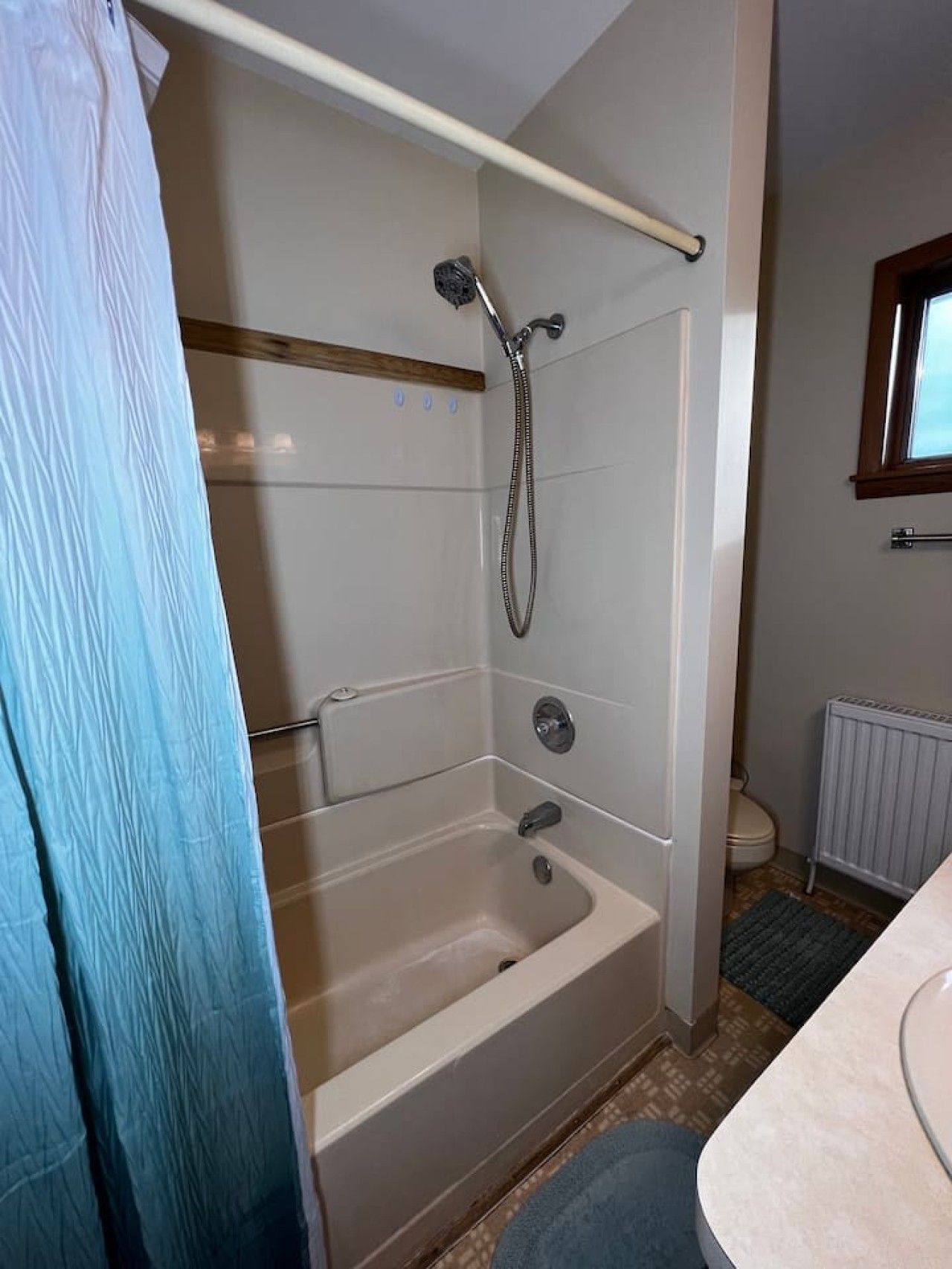 A bathroom with a bathtub, shower, and toilet.