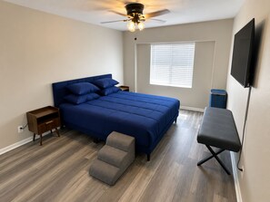 A bedroom with a bed, bedside tables, a desk, a chair, a ceiling fan, and a window with blinds. - Enjoyable 3-bedroom house with AC in sunny Clearwater (Clearwater)