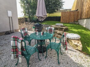 A patio with a round table, four chairs, a barbecue grill, and a covered umbrella. - Rockhurst Farm (Matlock)
