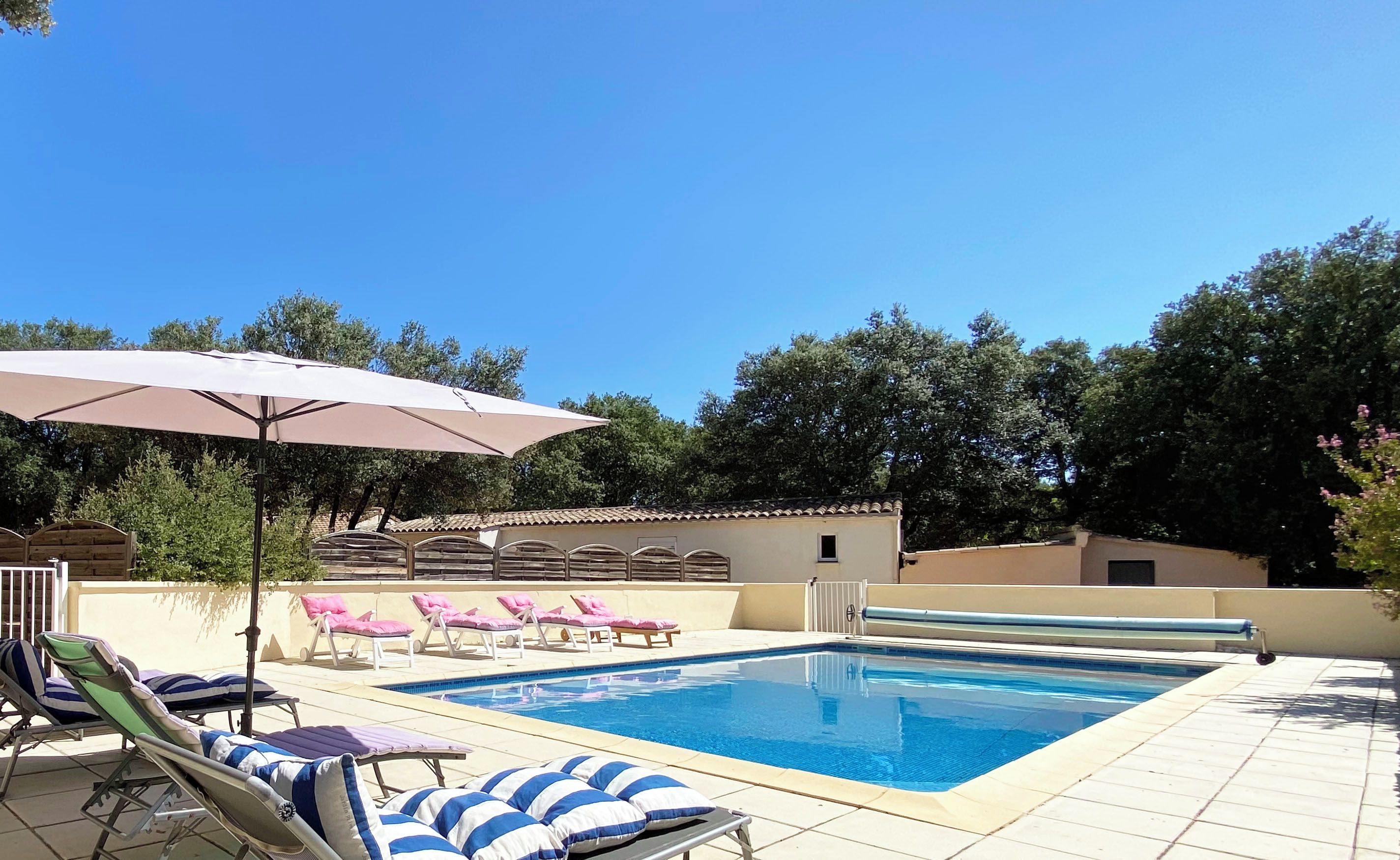 Une piscine avec des chaises longues et des parasols.