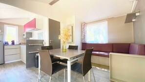 A compact kitchen with a dining area, a microwave, and a vase with flowers.