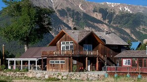 Eine Holzhütte mit Balkon, überdachter Veranda und Bergblick.