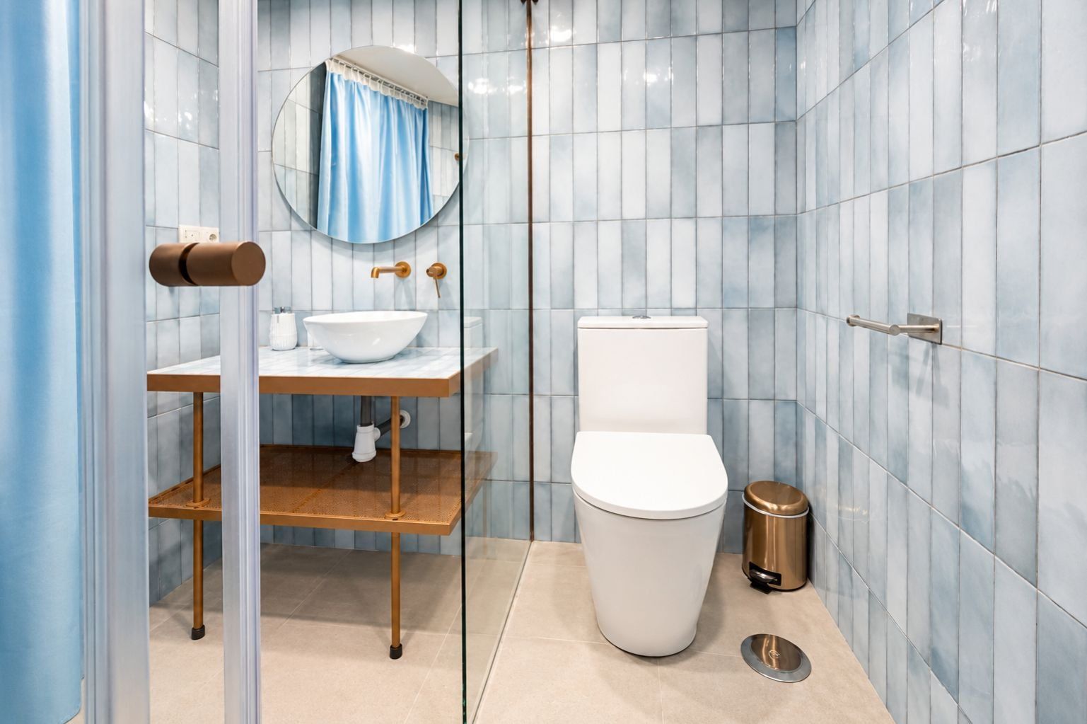 Un bagno moderno con il water, un lavandino e uno specchio.