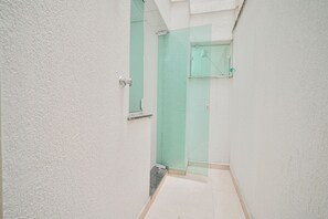 A narrow hallway with a door leading to a bathroom with a green shower enclosure. - Apartamento c Varanda Perto da Ufjf e do Aeroporto (Juiz de Fora)
