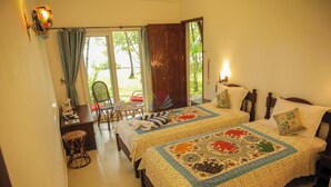 Un dormitorio con dos camas, un escritorio, una silla y vistas al exterior.