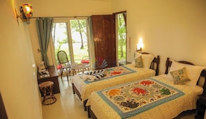 Une chambre avec deux lits, un bureau, une chaise et une vue sur lâextĂ©rieur.