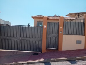 En lukket indgang med en metalport, en dør med nummer '11' og et lille vindue over døren.