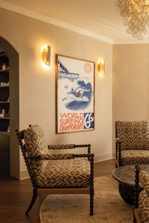 A room with a framed poster of the World Surfing Championships 66, two patterned chairs, and a round table. - OCEAN CITY MANSION (Ocean City)