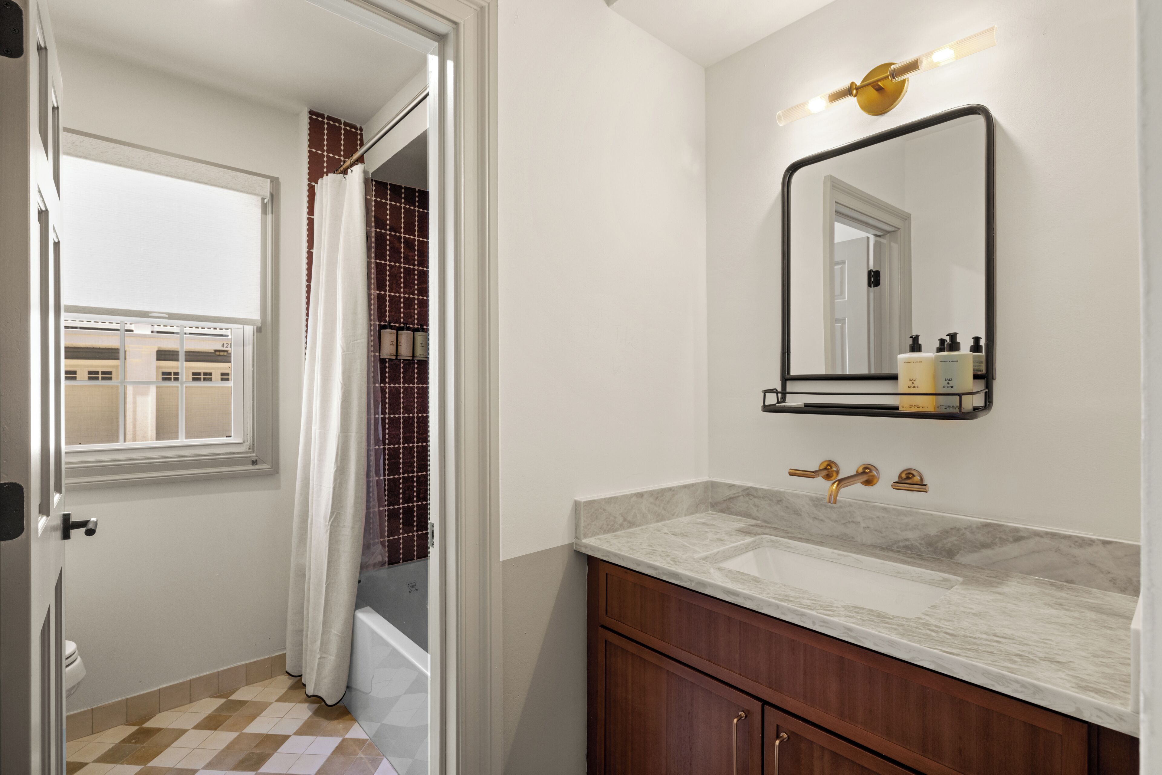 Un baño con lavabo, espejo y cortina de ducha.