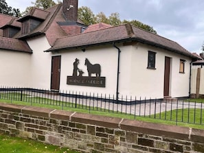 Un edificio con un letrero que dice 'HORSE & FARRIER' y la silueta de un jinete a caballo.