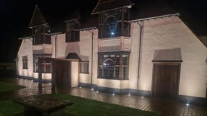 Un edificio grande de varios pisos con una fachada simétrica, ventanas amplias y una entrada central.
