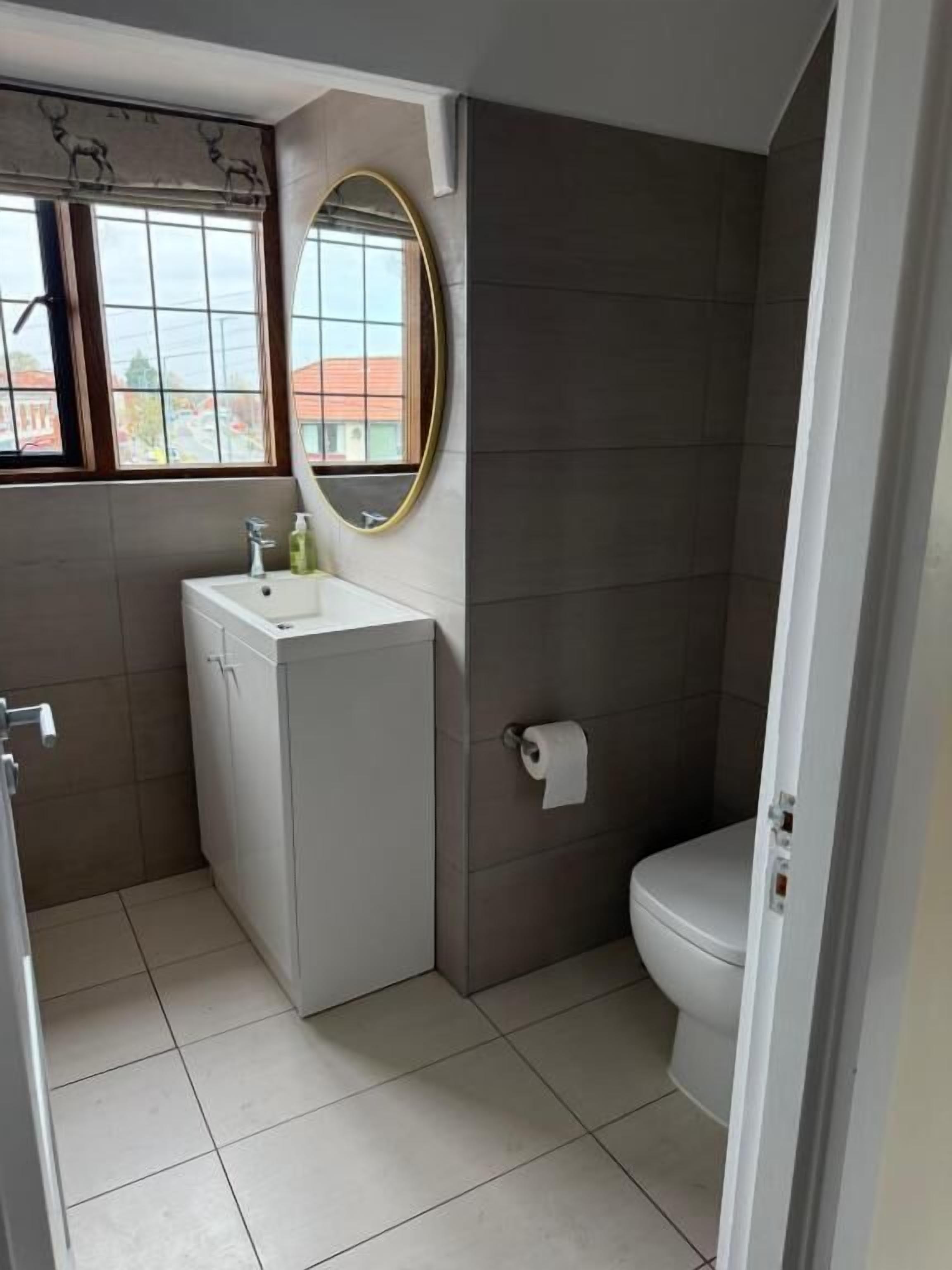 Un baño con lavamanos, inodoro y ventana.