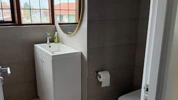 Un baño con lavamanos, inodoro y ventana.