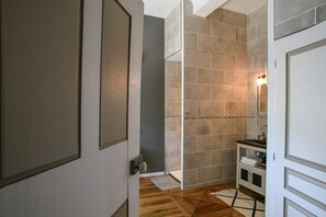 A bathroom with a shower, a sink, and a mirror.