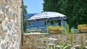 A stone wall, a table with chairs, a striped umbrella, and a view of the countryside. - Guest Room “Chambre du Parc”: Mountain View, Shared Terrace, Wi-Fi (Saint-Albin-de-Vaulserre)