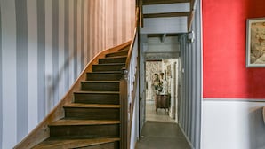 A staircase with wooden steps and a handrail, leading to a room with a red wall and a framed picture. - Guest Room “Chambre du Parc”: Mountain View, Shared Terrace, Wi-Fi (Saint-Albin-de-Vaulserre)