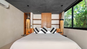Ein modernes Schlafzimmer mit einem großen Bett, einem Holzkopfende und Blick auf Grünflächen.