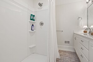 Kylpyhuone, jossa on suihku, wc, peilillä varustettu pesuallas ja pyyheteline.